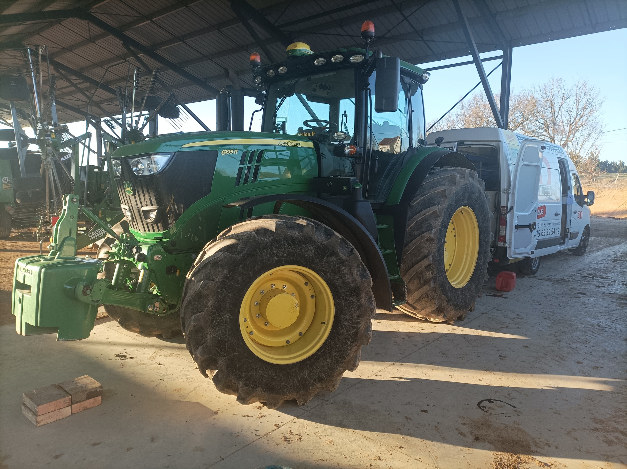 Tracteur John Deere 6195R en maintenance dans un hangar agricole md-services-mecanique-hydraulique-aveyron en Aveyron