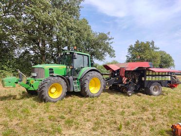 Tracteur John Deere au travail dans un champ avec matériel agricole, md-services-mecanique-hydraulique-aveyron en Aveyron