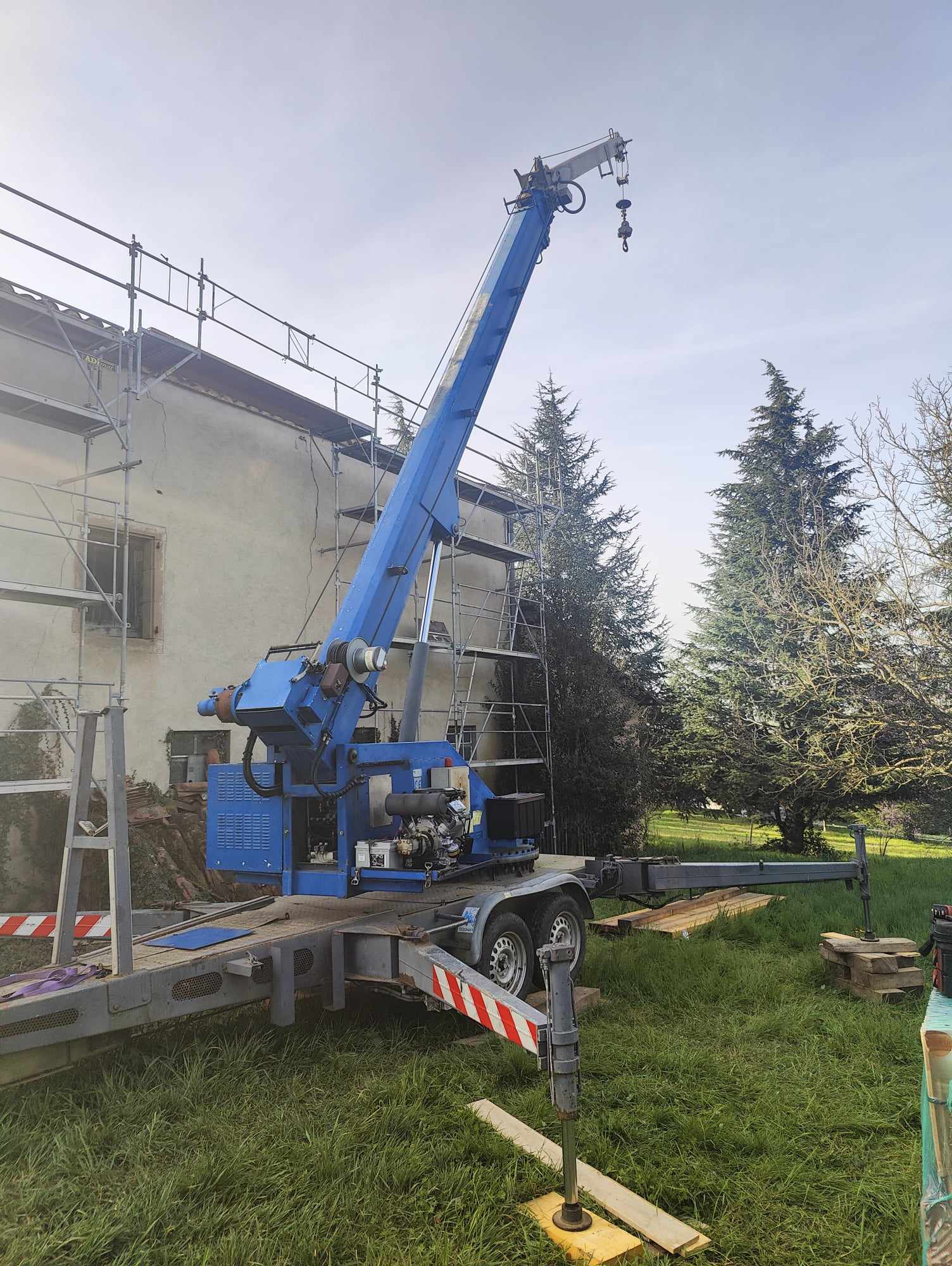 Grue mobile bleue sur remorque en intervention extérieure chez md-services-mecanique-hydraulique-aveyron en Aveyron