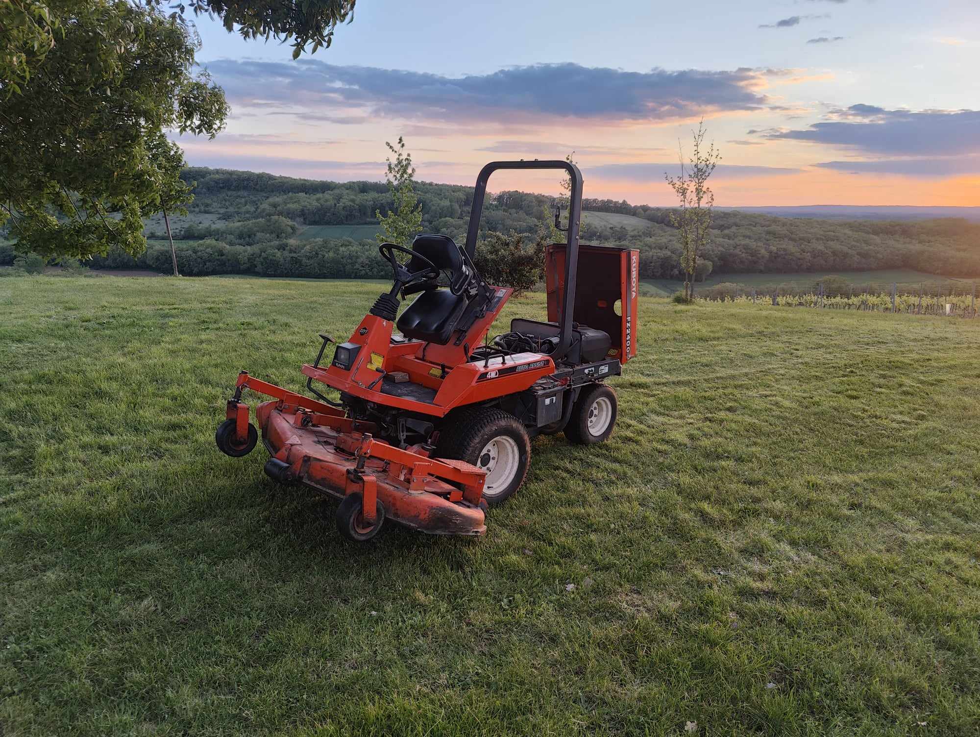 Tondeuse autoportée rouge sur pelouse au coucher du soleil, service md-services-mecanique-hydraulique-aveyron en Aveyron